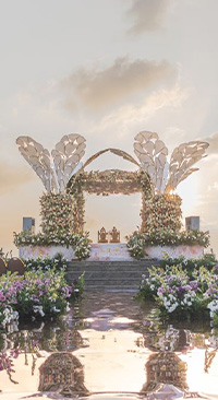 Floral mandap decoration with unique, leaf-like structures, reflecting on a Beach at sunset.