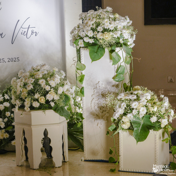 Close-up of elegant wedding decor featuring white floral arrangements on decorative pedestals.