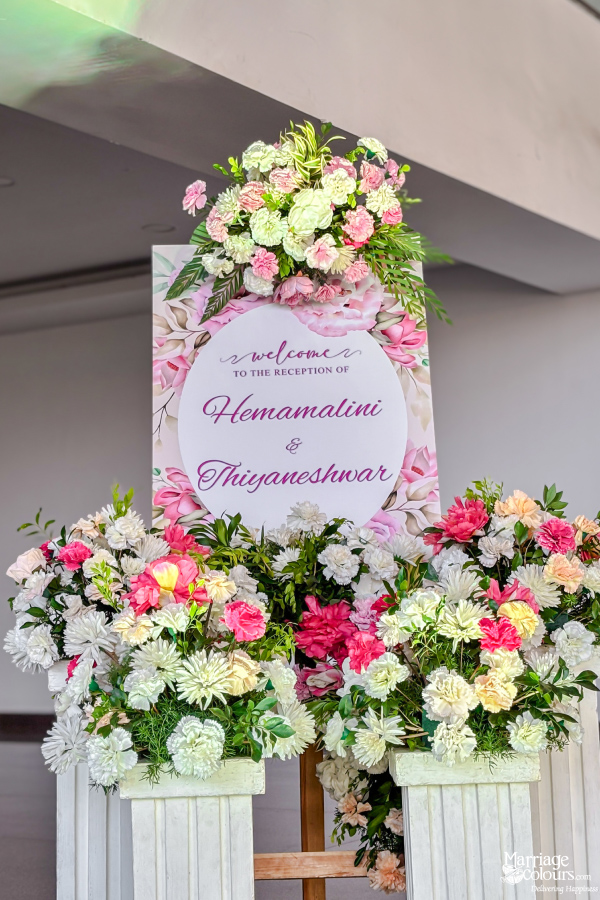 Wedding reception welcome sign for Hemamalini & Thiyaneshwar, surrounded by vibrant pink and white flowers.
