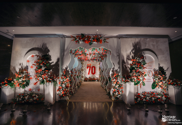 Grand event entrance with floral arches, a wavy tunnel, and a central red '70' sign.