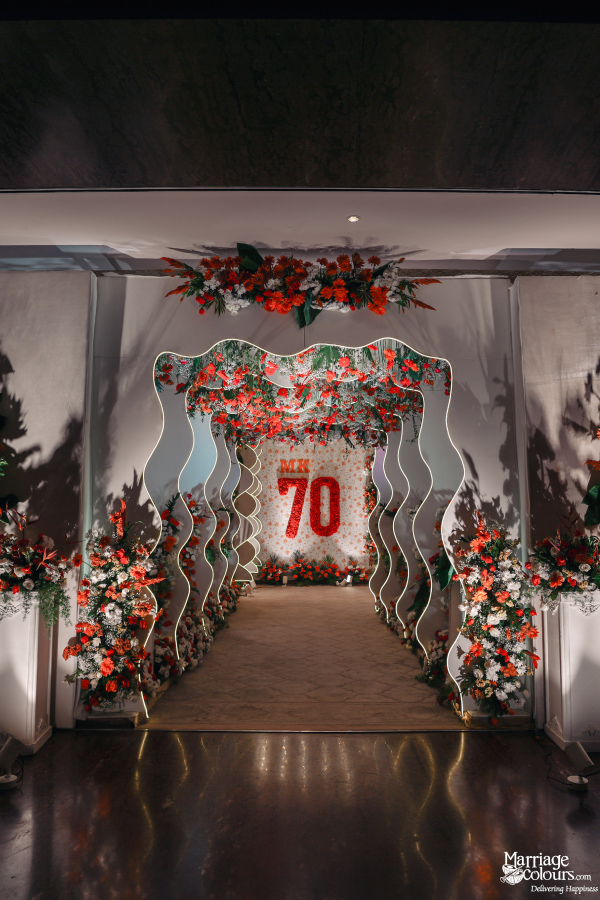 Walkway entrance decorated with wavy white arches and red and white flowers.