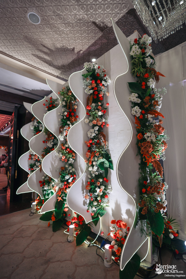 Decorative wall of wavy white panels highlighted with orange and white flowers.