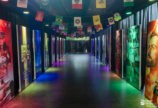 A long, dramatic hallway lined with large posters of sports legends under colorful draped international flags.