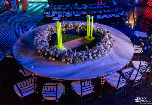 A large marble-look table with a cricket pitch and fluorescent yellow stumps as the floral centerpiece.