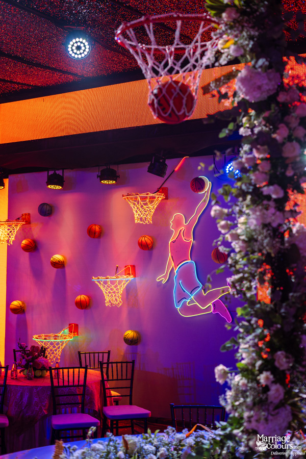 A vibrant basketball-themed party decor featuring a neon dunking player and multiple illuminated hoops.