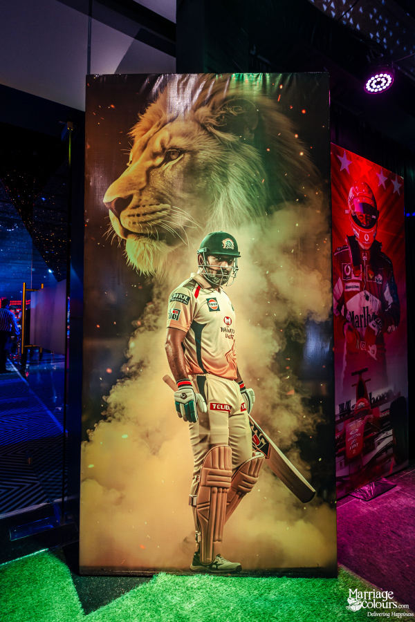 A large, dynamic banner of a cricket player in uniform, framed by smoke and a lion graphic.