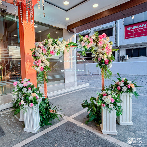 Floral welcome sign with a clear acrylic board surrounded by pink and white flowers.