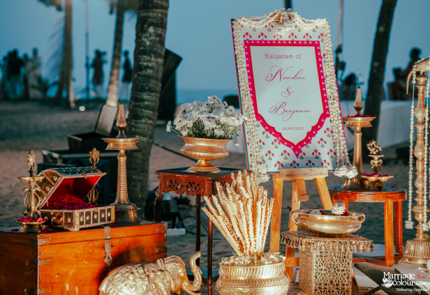 Wedding welcome sign for Nandini and Benjamin, surrounded by brass ceremonial items and flowers.