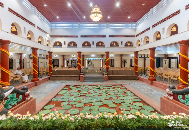 Grand traditional hall with elephant statues framing a lotus pond and event seating.