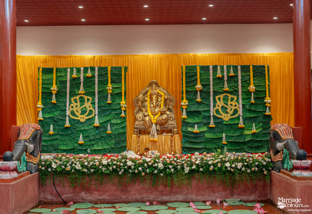 raditional wedding stage with a Ganesha idol, banana leaf backdrop, and elephant statues.