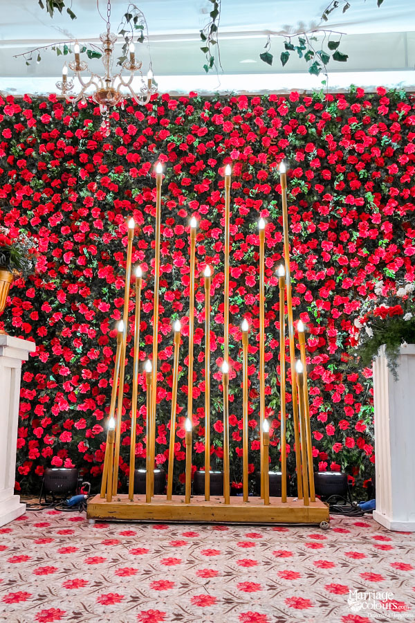 Wedding photo booth with a hexagonal arch, greenery wall, and two decorative motorbikes.