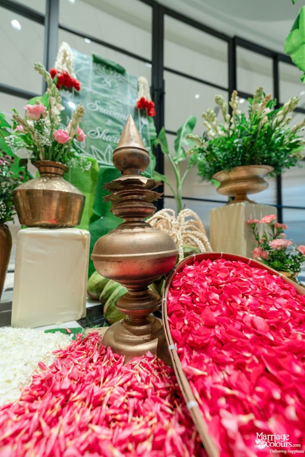 A close-up of a decorative brass lamp surrounded by bright pink and white flower petals.