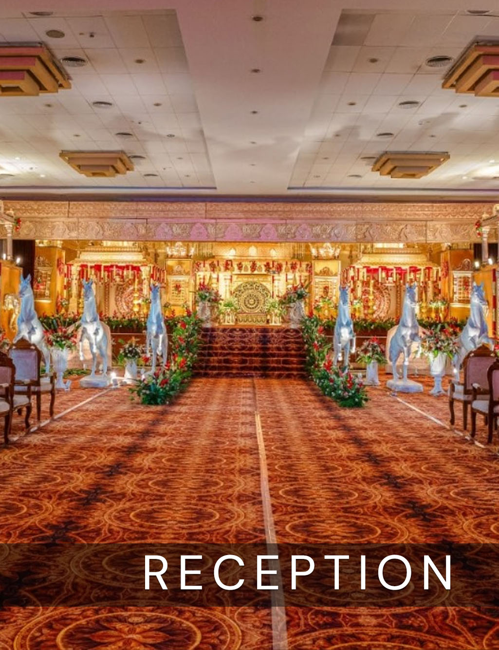 Grand traditional reception stage with white horse statues lining the red patterned carpeted aisle and stairs.