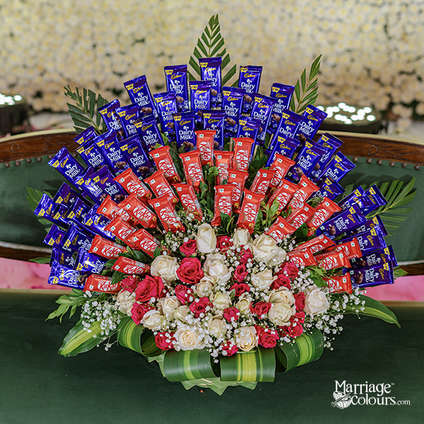 Traditional leaf basket with chocolates and pink rose floral arrangement for baby shower return gift at ITC Grand Chola Chennai