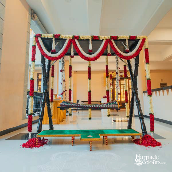 Traditional South Indian wedding swing (oottu padi) decorated with red and white flowers