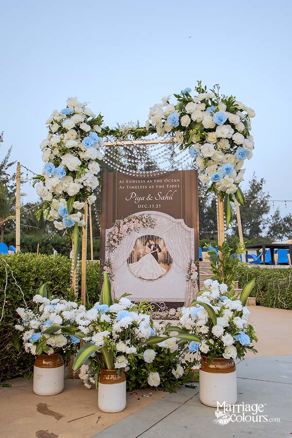 Romantic heart-shaped floral arch with couple’s photo and wedding date, surrounded by white and blue blooms