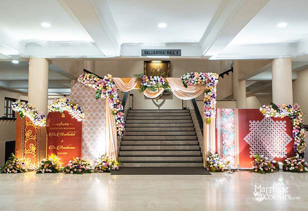 Grand wedding entrance at Valliammai Hall with floral arches, draped fabric, and personalized welcome signage