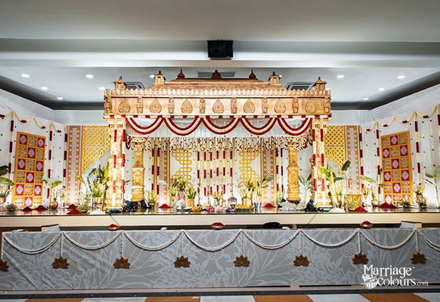 South Indian wedding hall with decorated mandap and white seating arrangement