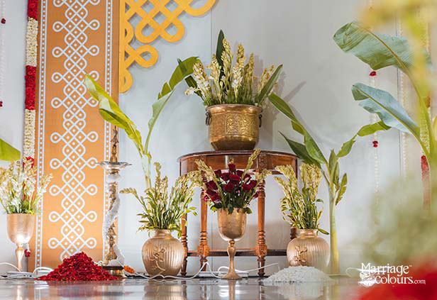 Traditional kalash decor with brass lamps, banana leaves and flowers for South Indian wedding entrance