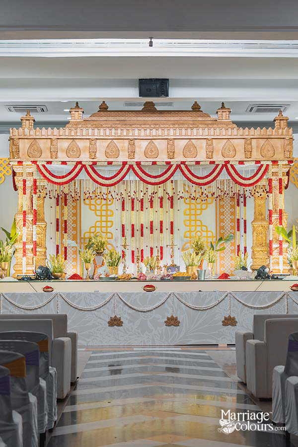 Traditional wedding mandap stage decoration with hanging flowers and colorful backdrop