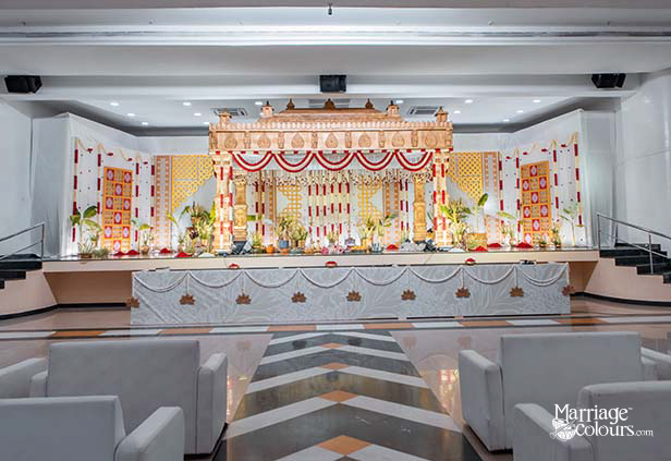 South Indian wedding stage with golden mandap and decorative side panels