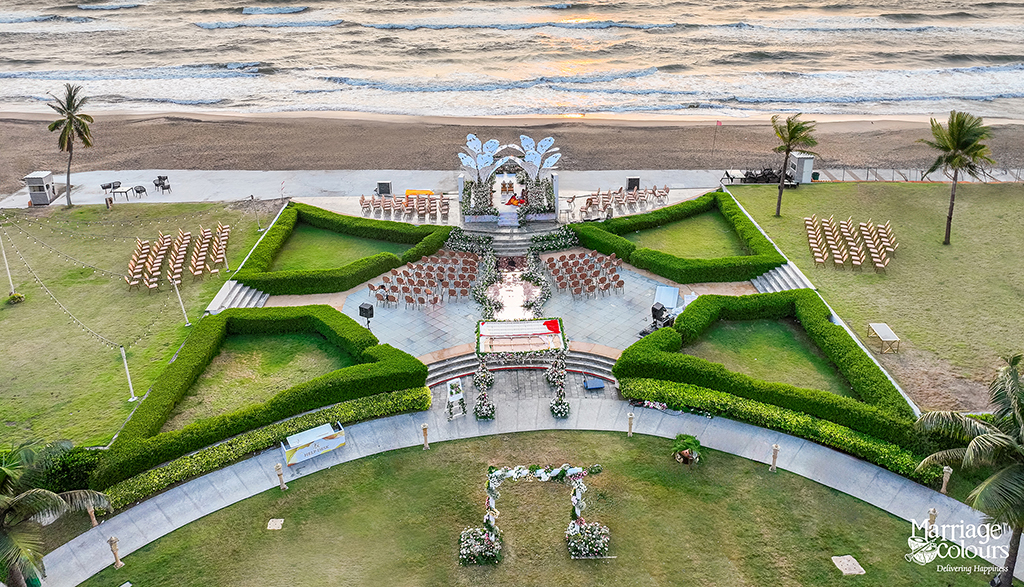 Aerial view of a beach destination wedding setup in Mahabalipuram with mandap, seating arrangement, and ocean backdrop