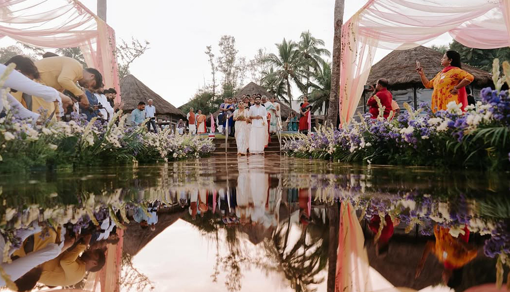 Eco friendly beach wedding décor by Mariage Colours featuring a sustainable mandap structure made of woven bamboo, local pampas grass, and potted palms on a coastal lawn.